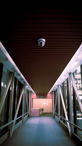 a long hallway with metal railings and a ceiling light