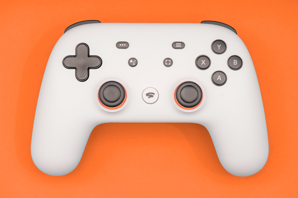 a close up of a white controller on an orange background