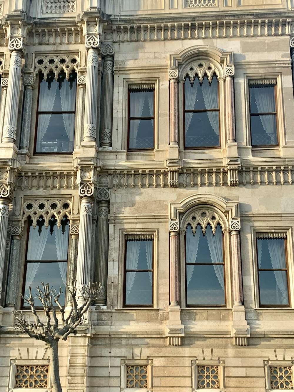 a large building with many windows and a tree in front of it