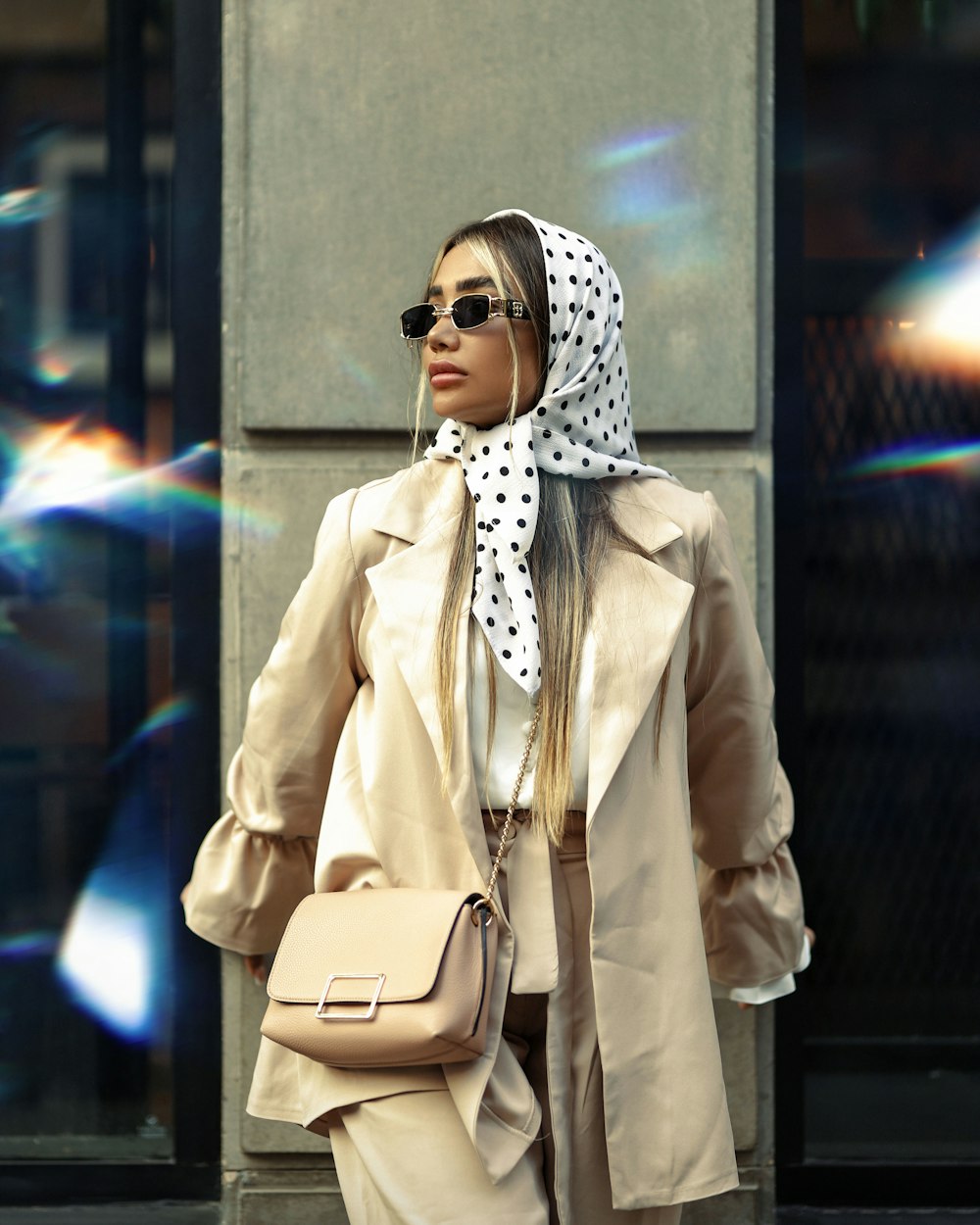 a woman in a trench coat and a polka dot scarf
