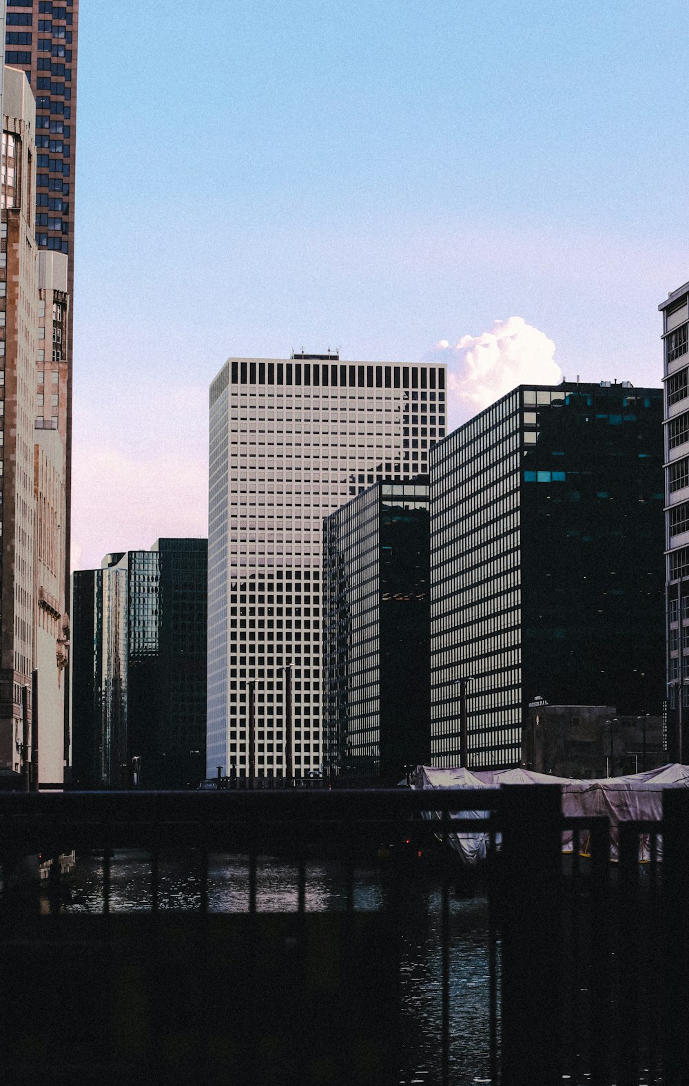 a city skyline with tall buildings and a bridge