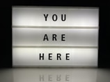 a lit up sign that says you are here