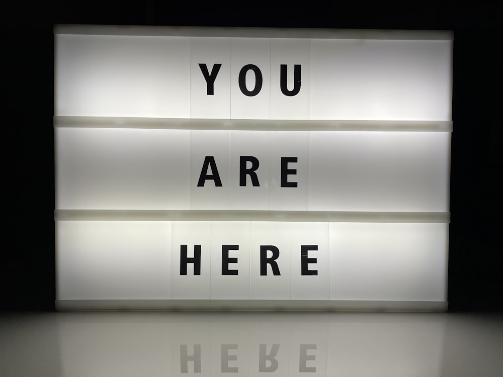a lit up sign that says you are here