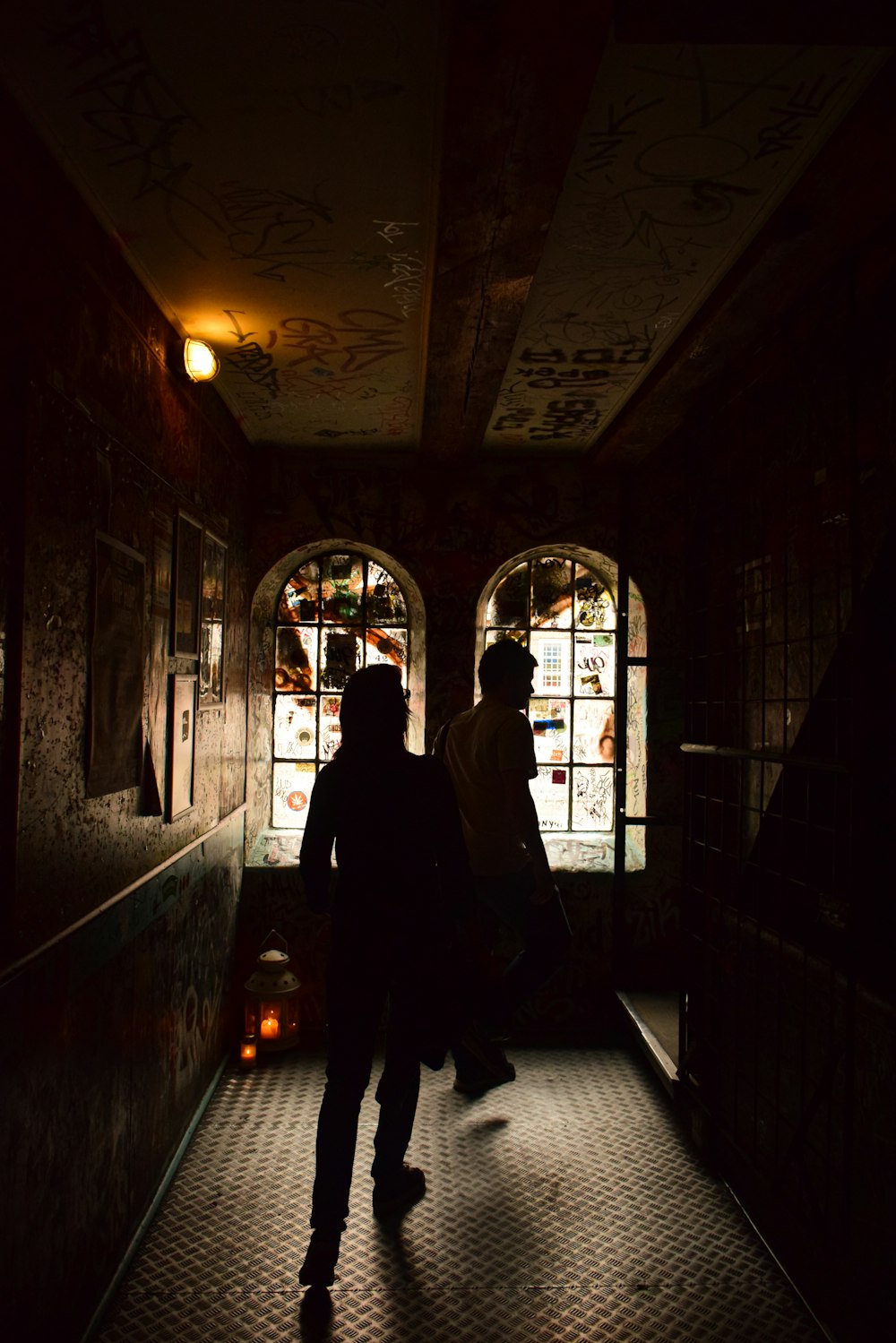 a couple of people walking down a dark hallway