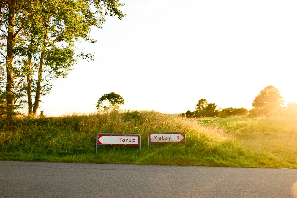 a couple of signs sitting on the side of a road