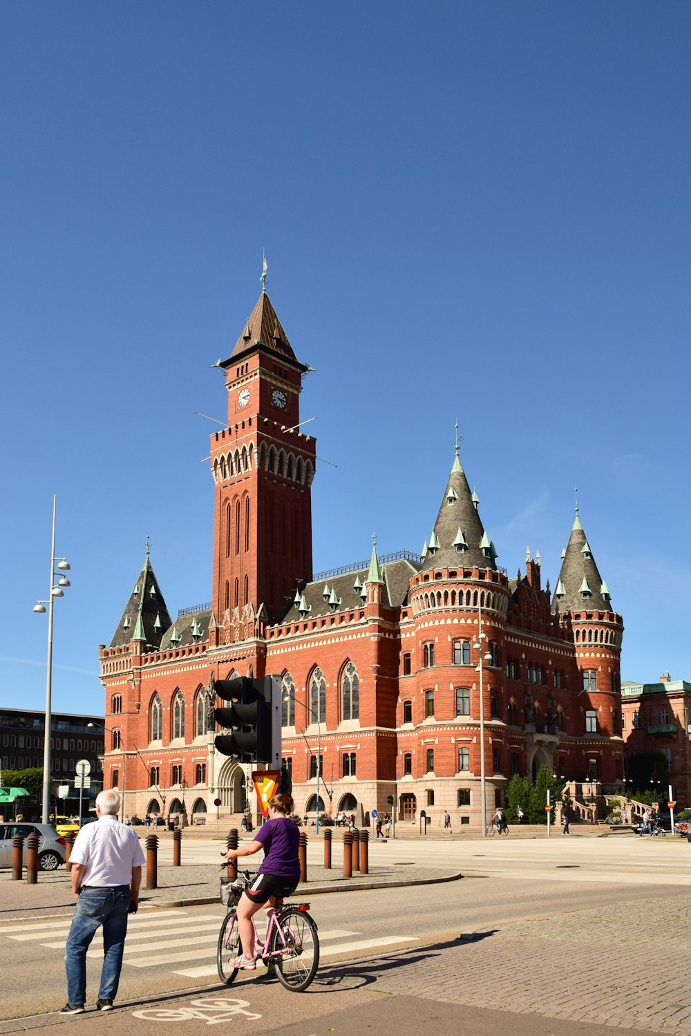 a person riding a bike in front of a large building