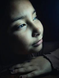 A close-up of a young student reflecting quietly with a soft smile.