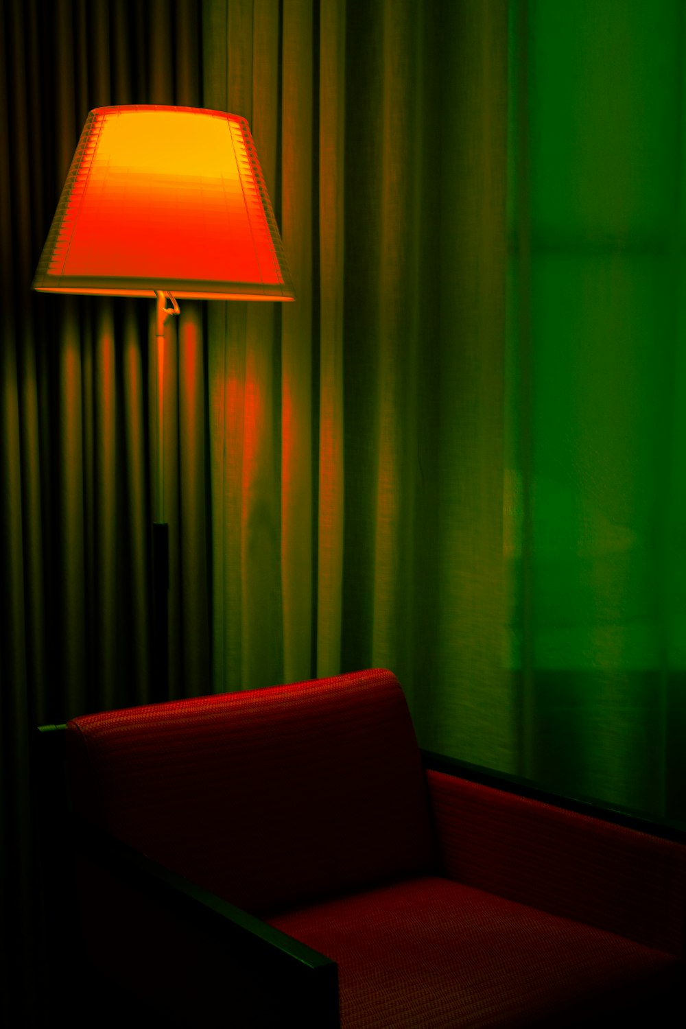 a red chair sitting next to a lamp in a room