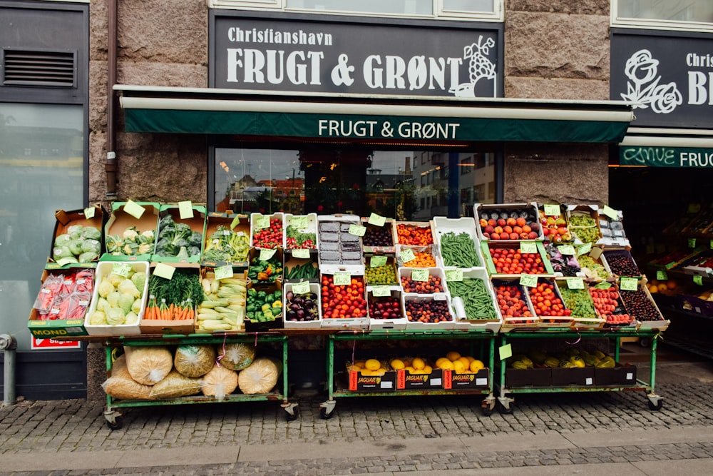a fruit and vegetable stand in front of a store