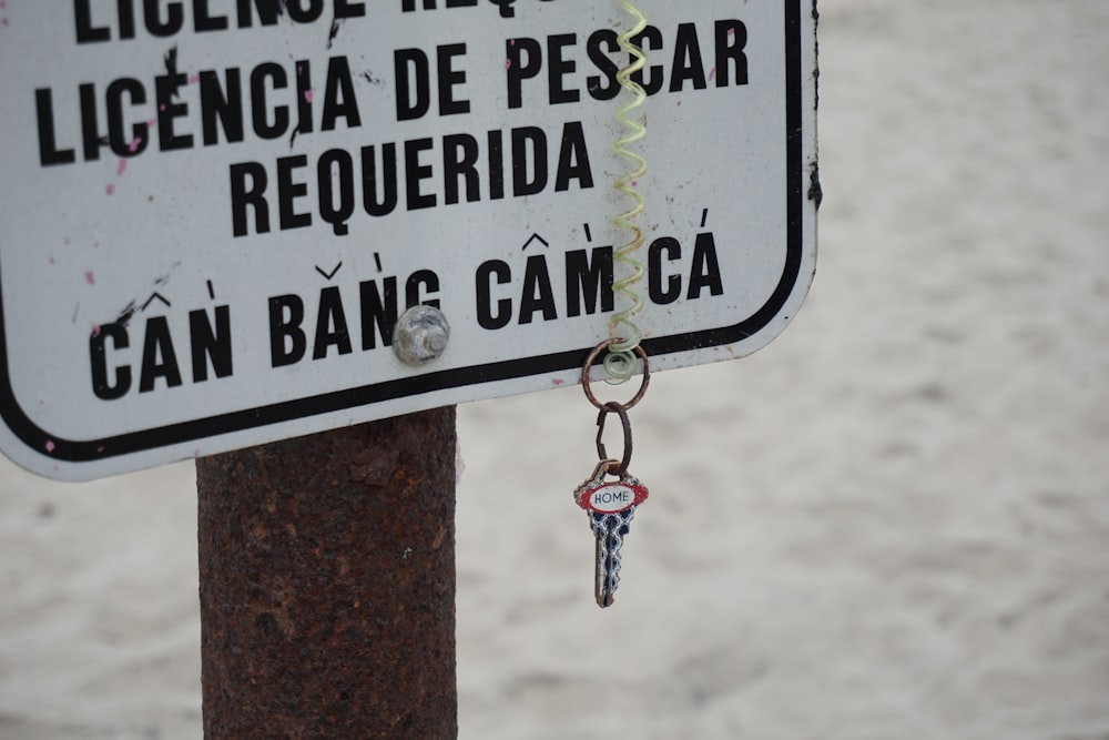 a white sign with a key hanging from it