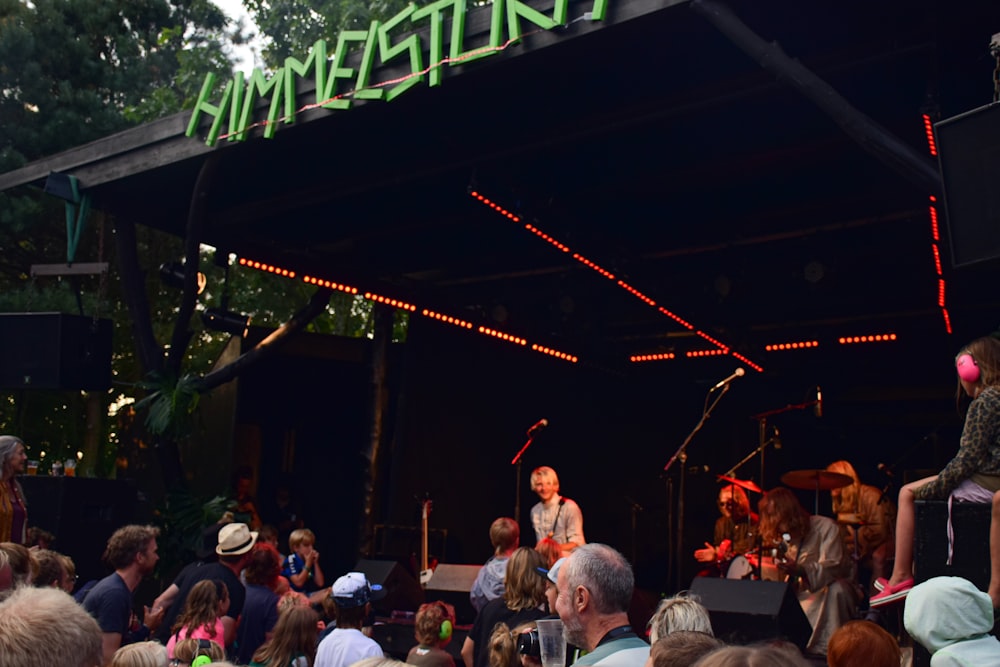 a group of people sitting and standing around a stage