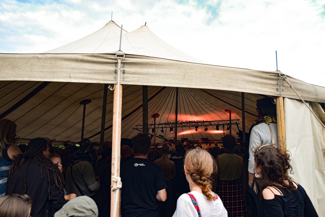 a group of people standing around a tent, Denmark - July 2016: Pavilion Tent. Facilities at Himmelstorm Festival. A smal