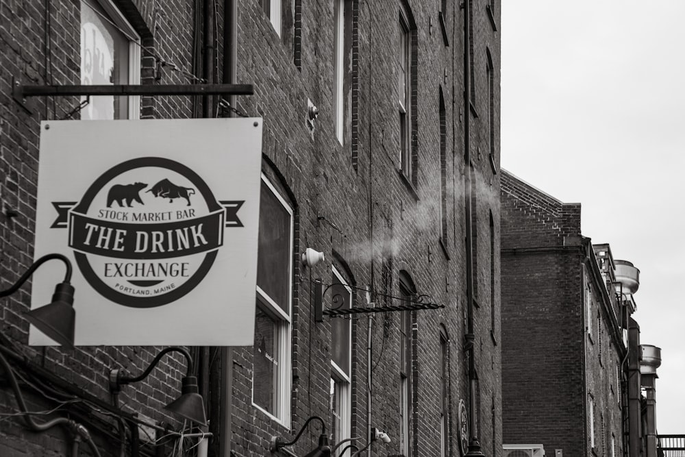 a sign hanging from the side of a brick building