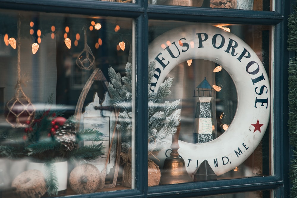 a store window with a christmas wreath and a clock