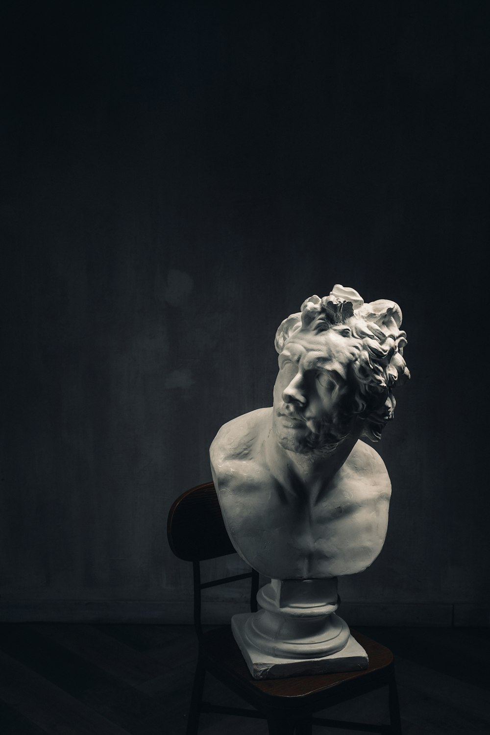 a bust of a man sitting on top of a chair