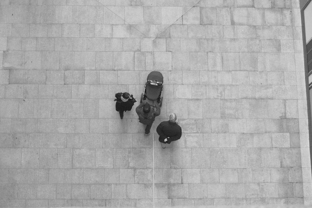 a black and white photo of a skateboarder and two people