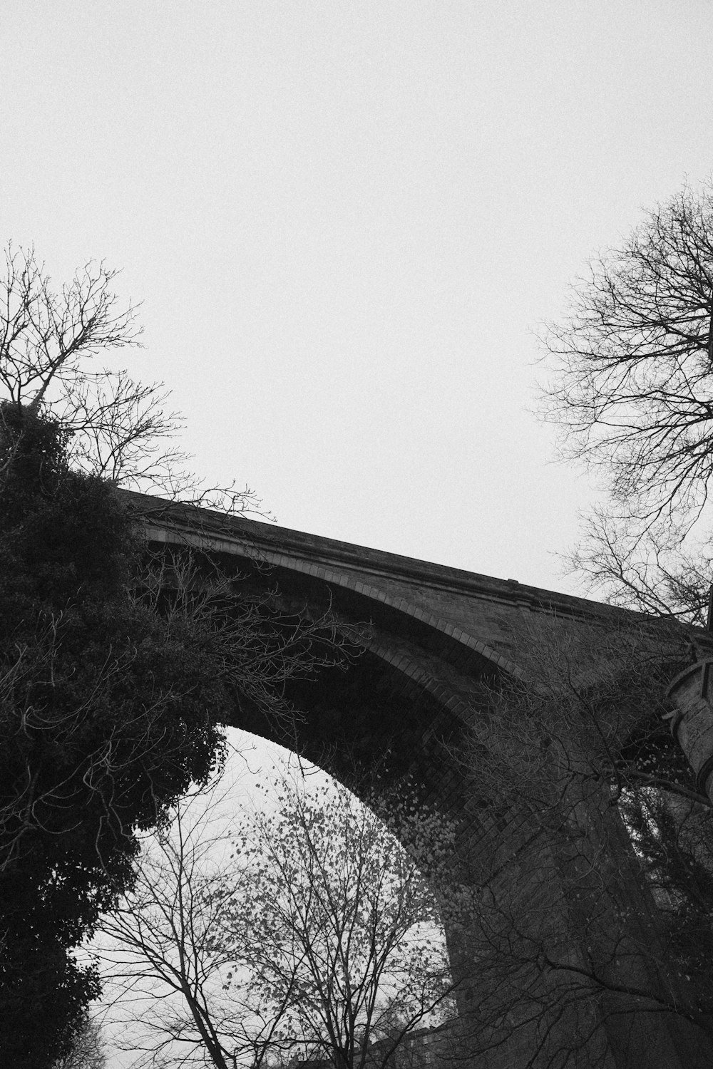 a black and white photo of an old bridge