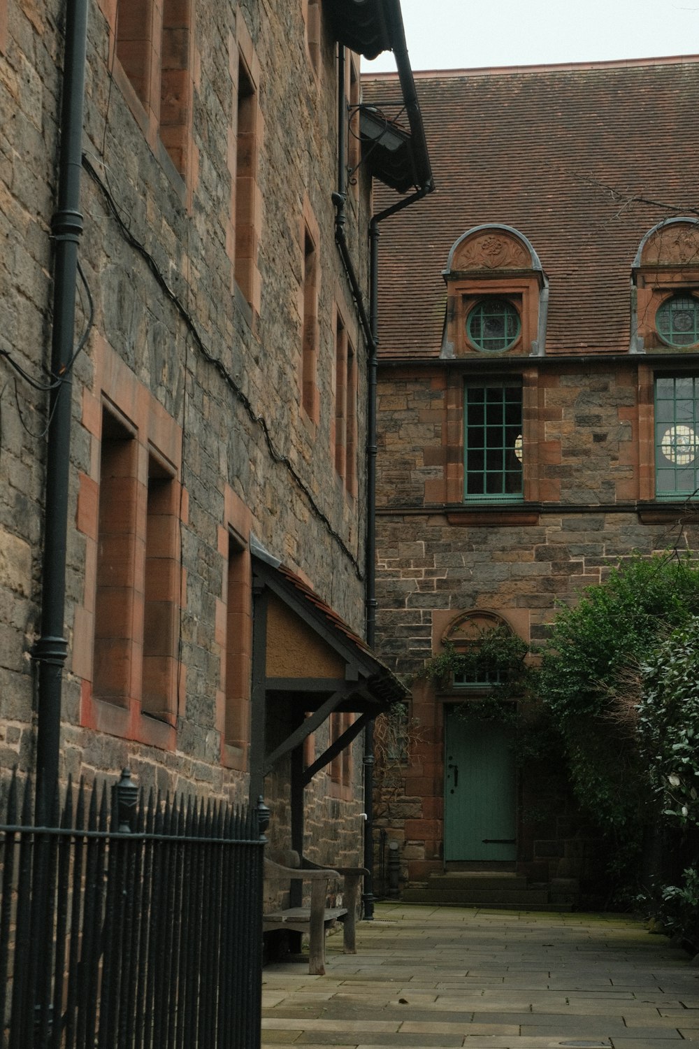 a brick building with a green door and a black fence