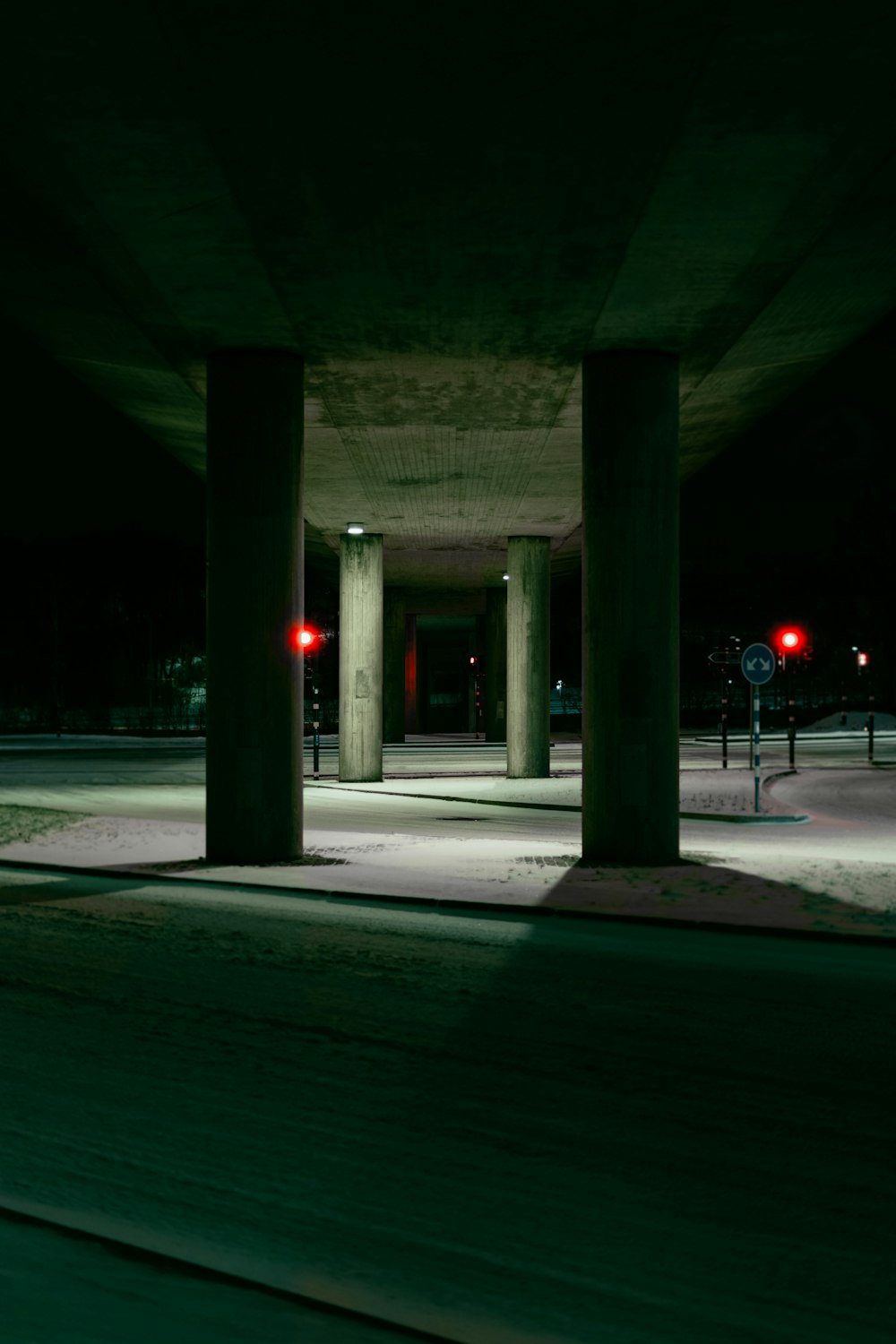 an empty parking lot at night with a red stop light