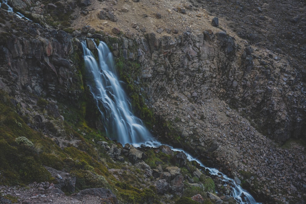 a waterfall is seen from the top of a mountain