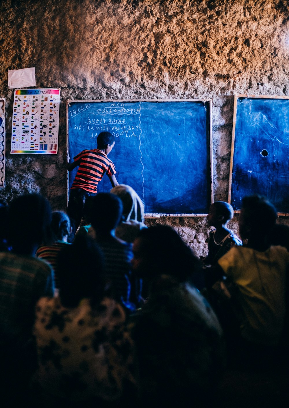 a man writing on a chalkboard in front of a group of people