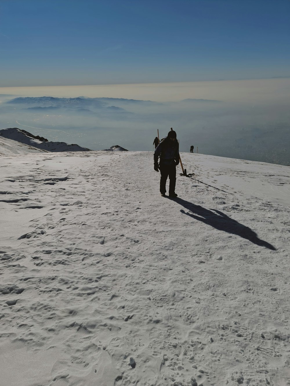 a man walking up a snow covered mountain