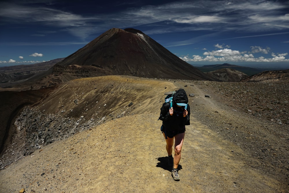 a person with a backpack walking on a dirt road