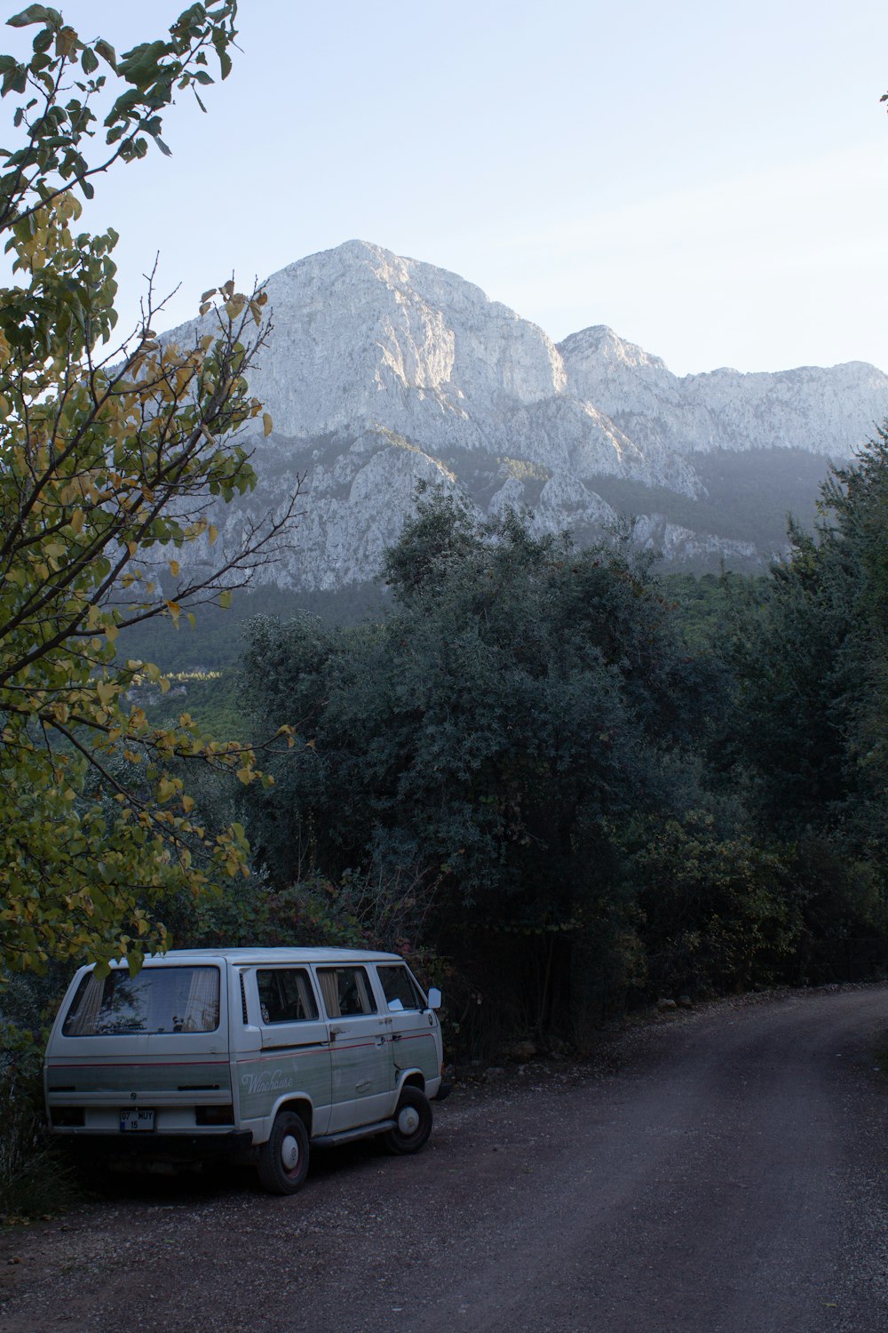 a van parked on the side of a dirt road