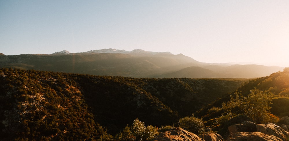 a view of a mountain range with the sun setting