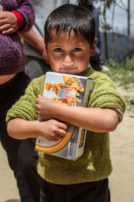 a young boy holding a book in his hands