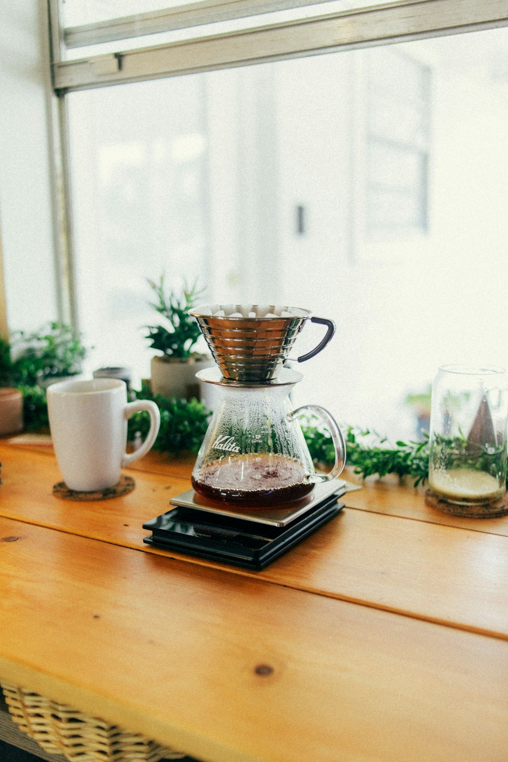 a wooden table topped with a coffee pot filled with liquid