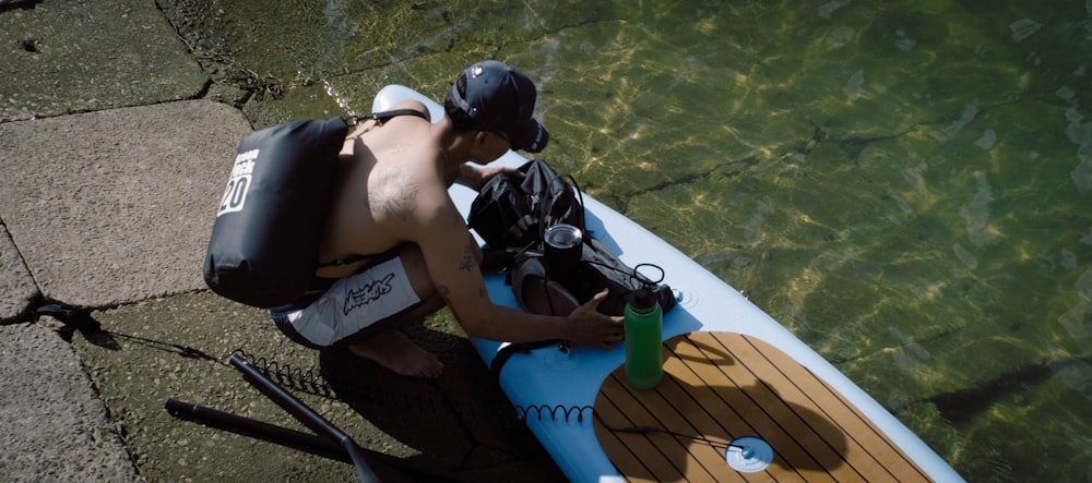 um homem sentado em um pequeno barco em um corpo de água