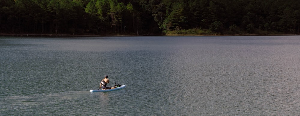 um homem em um barco pequeno em um lago