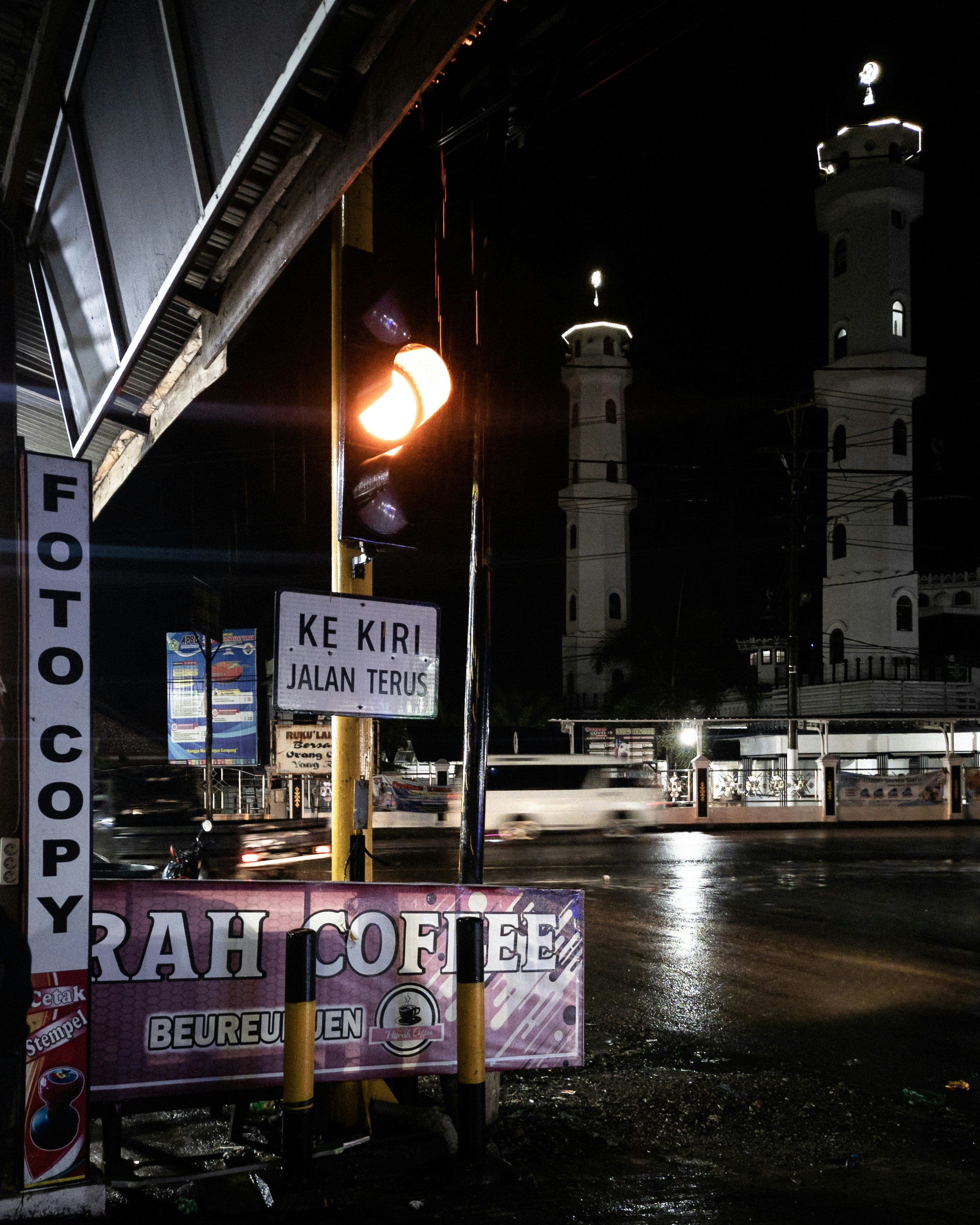 uma luz de rua sentada ao lado de uma placa