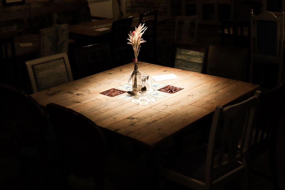 uma mesa de madeira com um vaso de flores em cima dela
