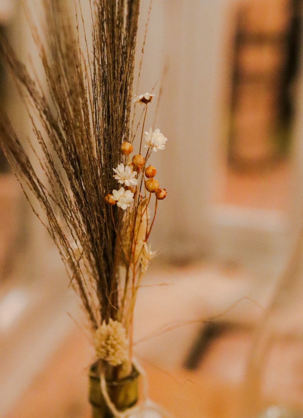 un vase rempli de fleurs séchées sur une table