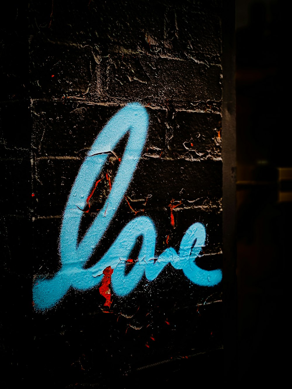 a brick wall with blue graffiti on it