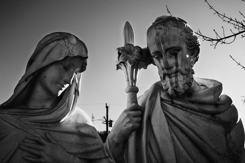 a black and white photo of two statues of jesus and mary