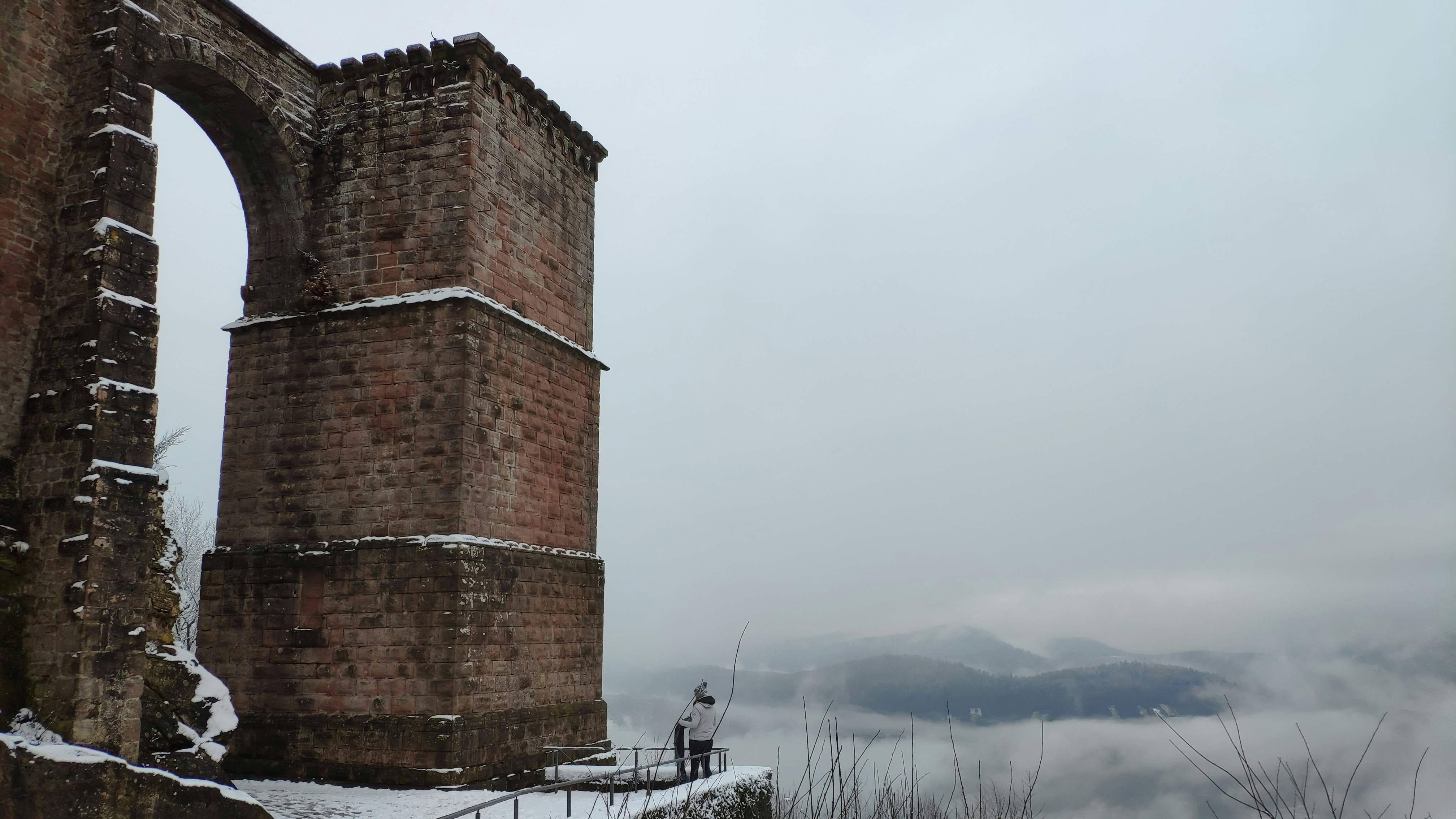 a tall brick structure sitting on top of a snow covered hillside