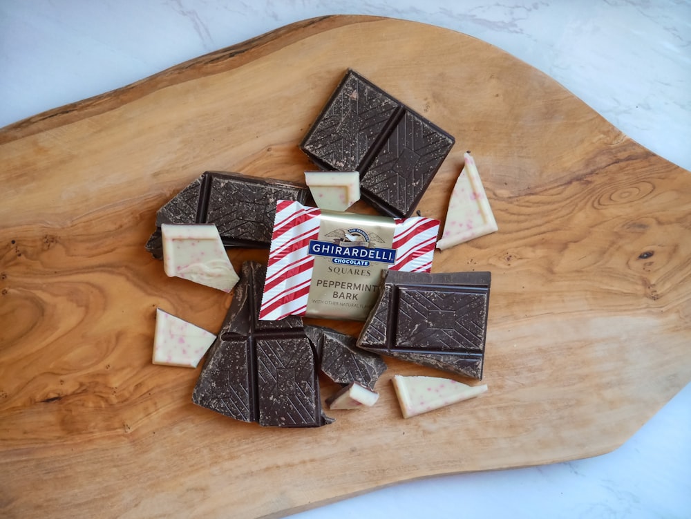 a wooden cutting board topped with pieces of chocolate