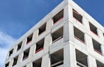 a tall concrete building under a blue sky