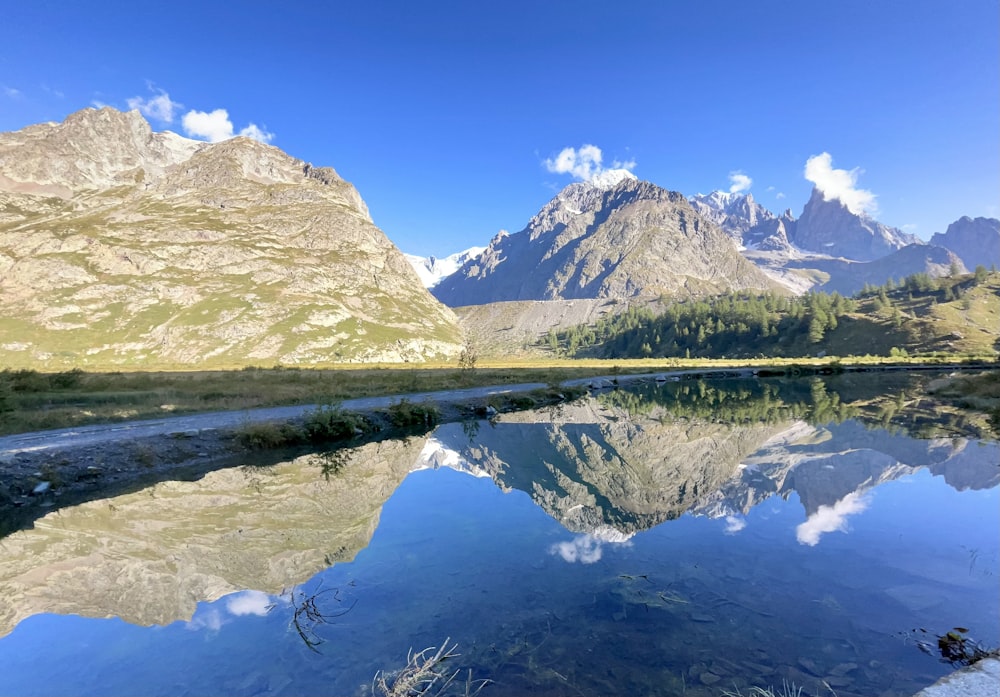 a mountain range is reflected in the still water of a river