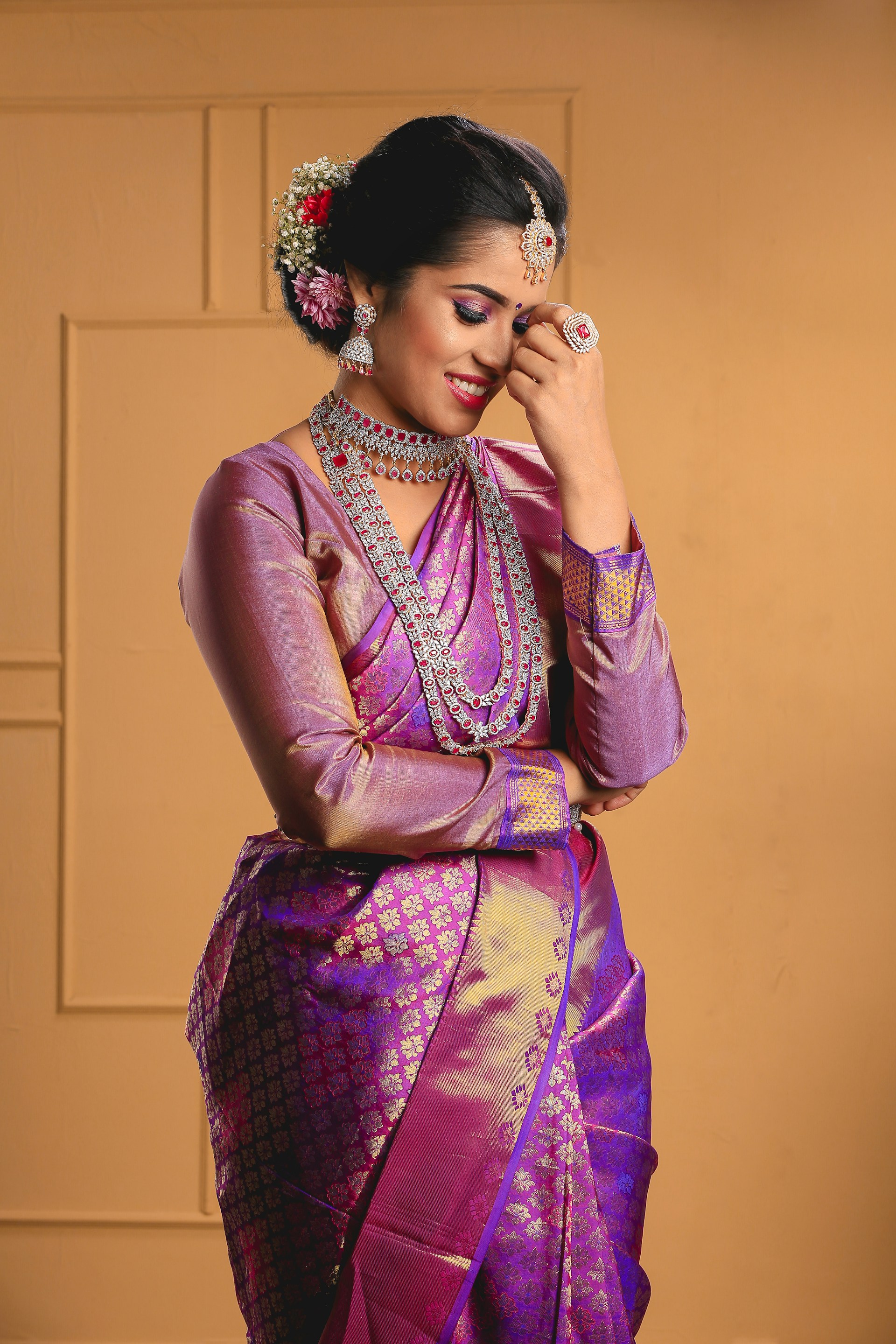 a woman in a purple and gold sari
