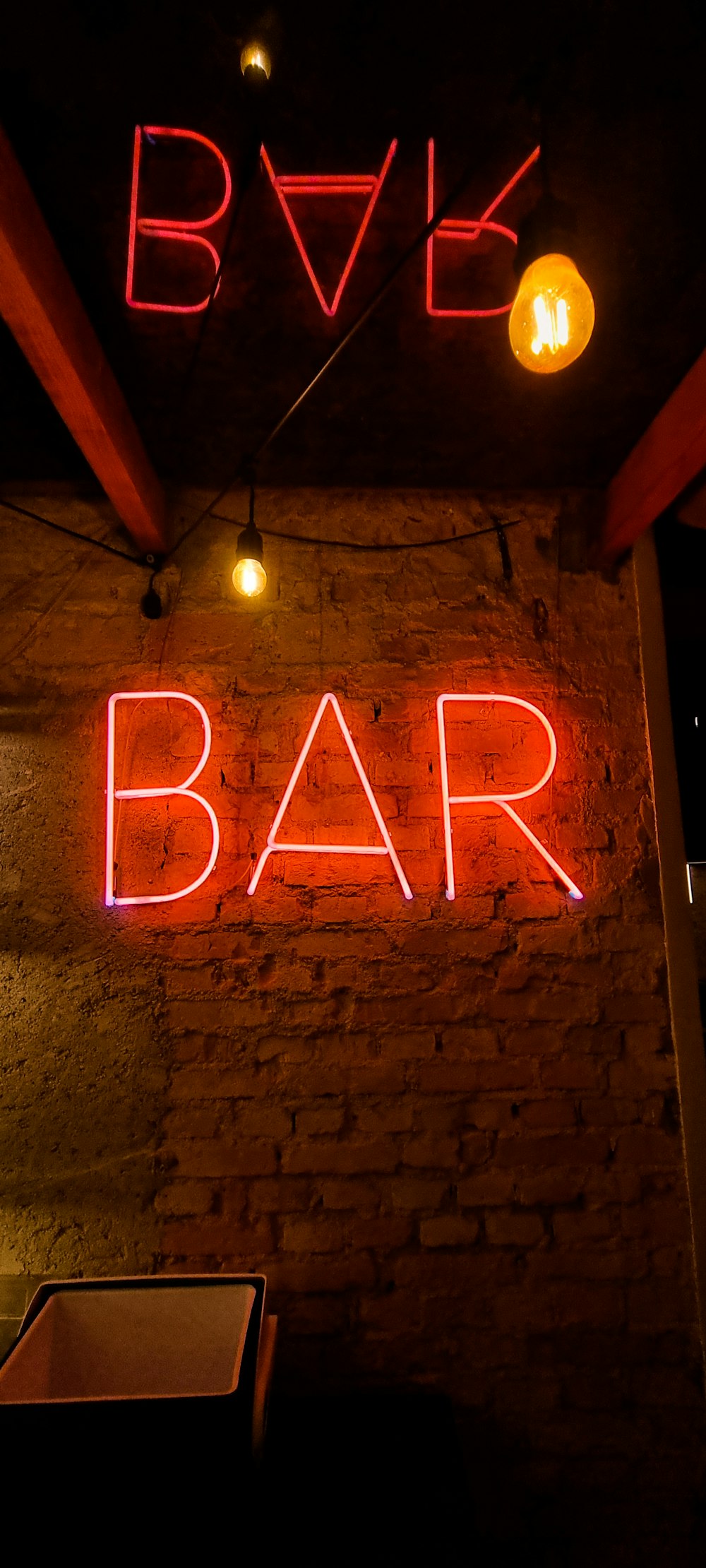 a brick wall with a neon sign on it