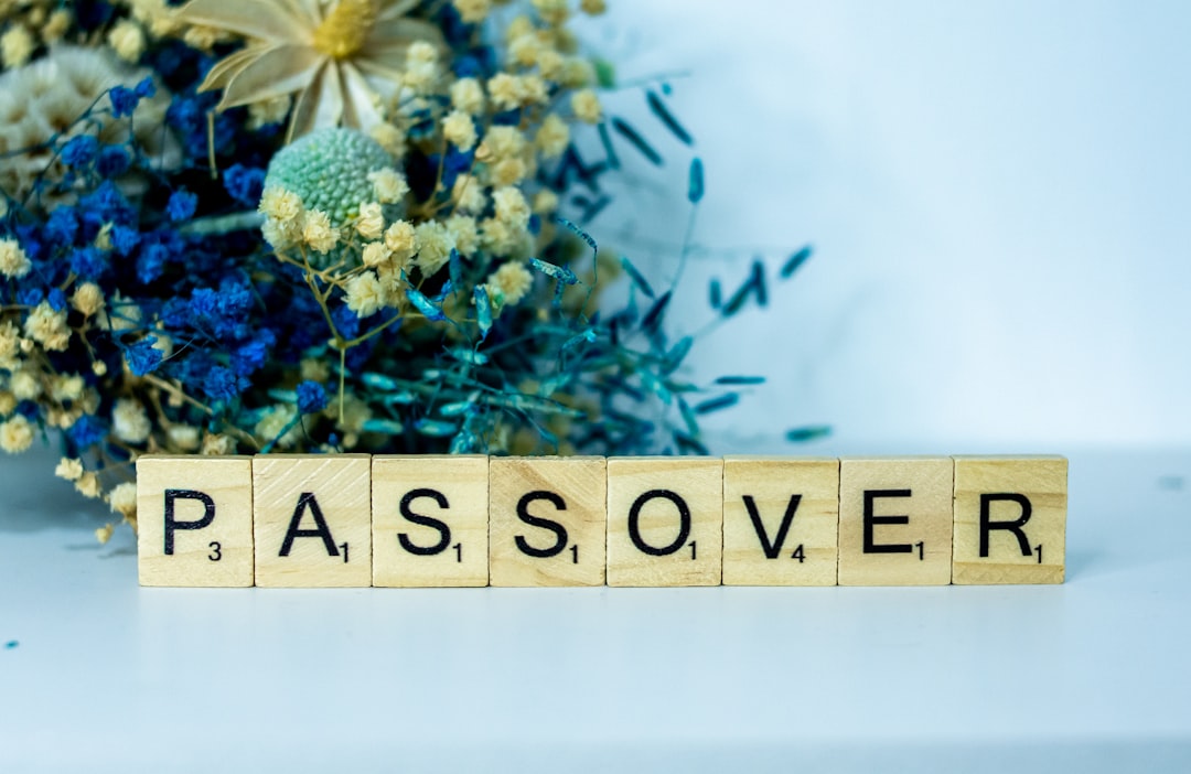 a wooden block spelling passover next to a bouquet of flowers