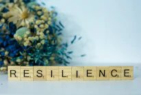 a scrabble type block spelling the word resilince