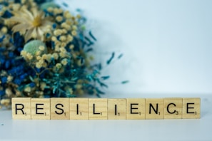 a scrabble type block spelling the word resilince