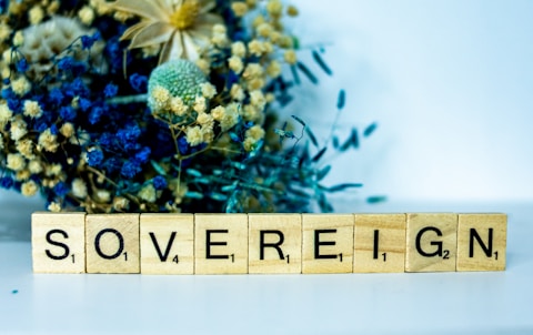 a wooden block that says sovereignn next to a bouquet of flowers