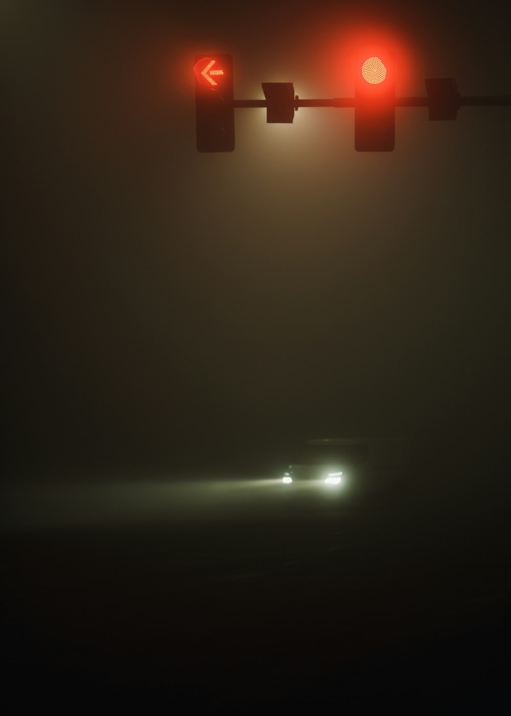 a car driving down a foggy street at night