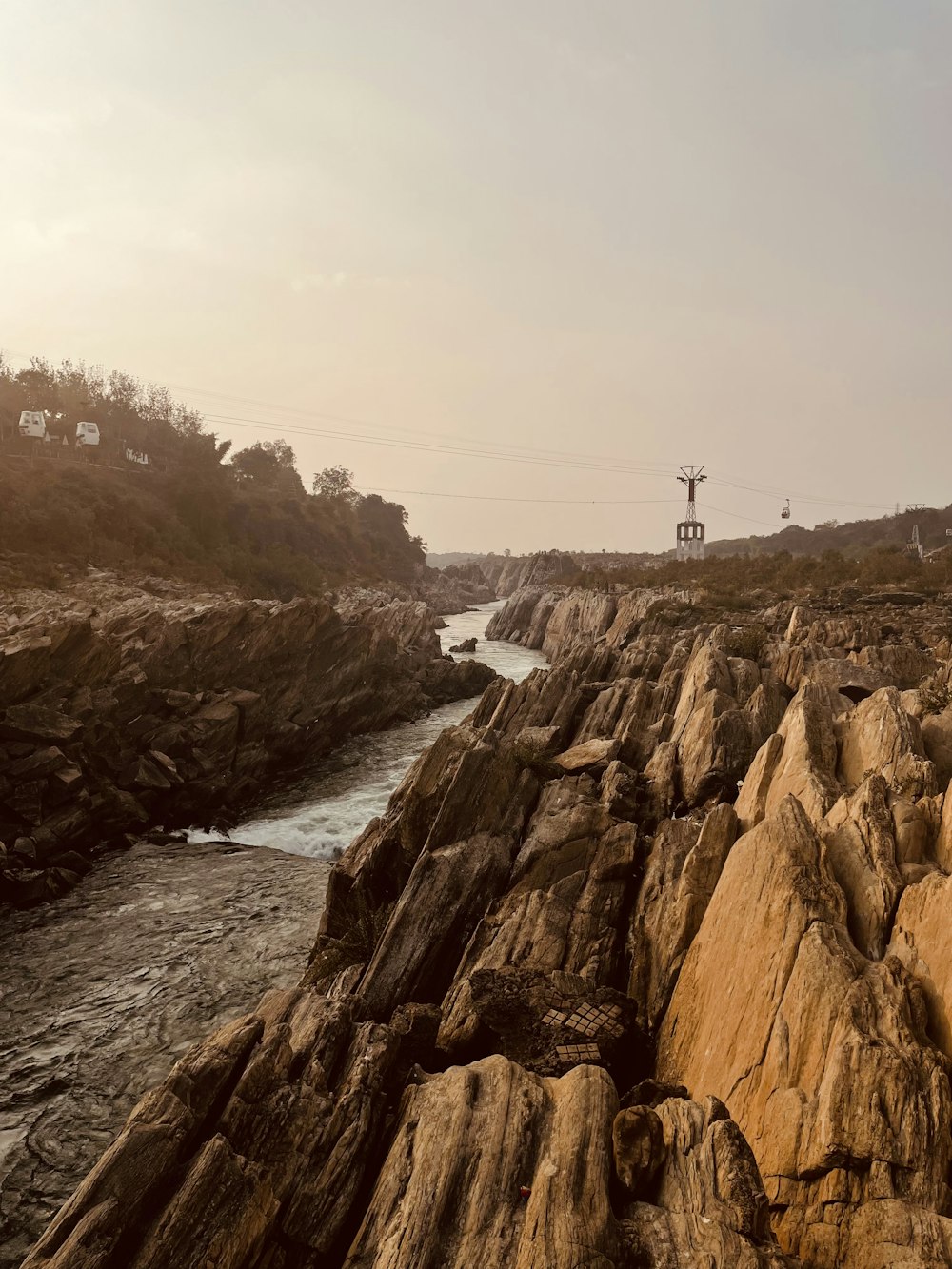 a rocky cliff with a river running through it